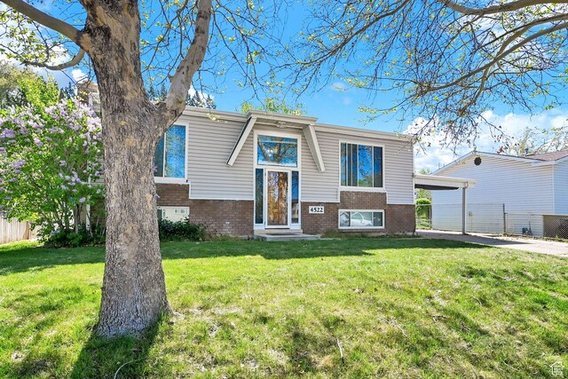 4522 S 2675 W, Roy, UT 84067 - raised ranch featuring brick siding, fence, a front yard, and a carport