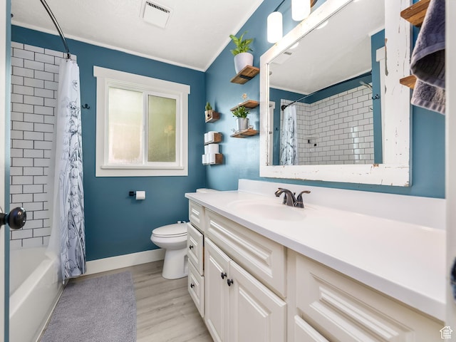 bathroom featuring shower / bath combo, vanity, toilet, wood finished floors, and ornamental molding