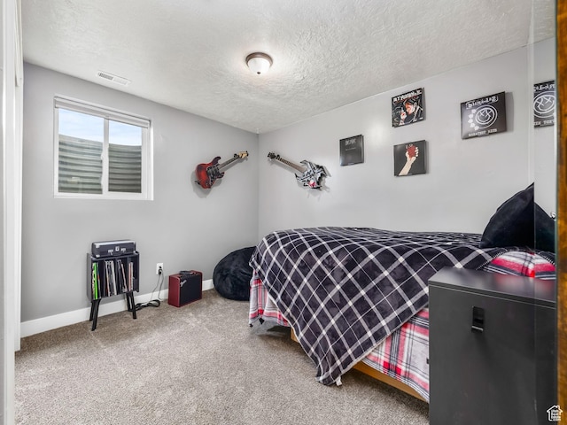 carpeted bedroom with visible vents, a textured ceiling, and baseboards