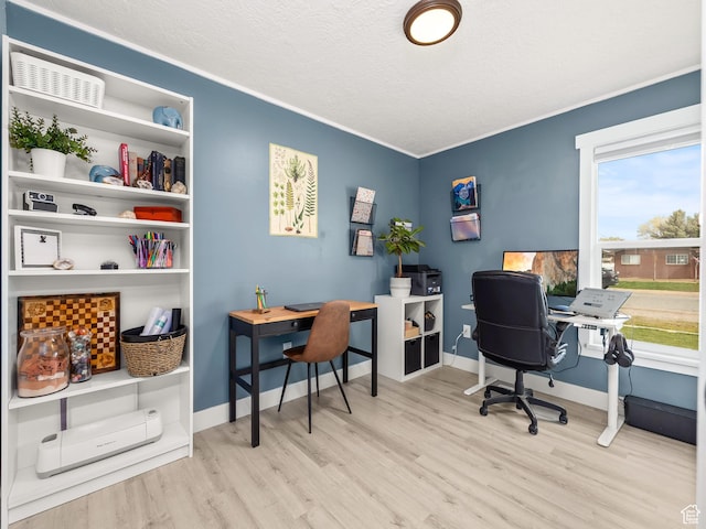 home office featuring a textured ceiling, ornamental molding, baseboards, and wood finished floors