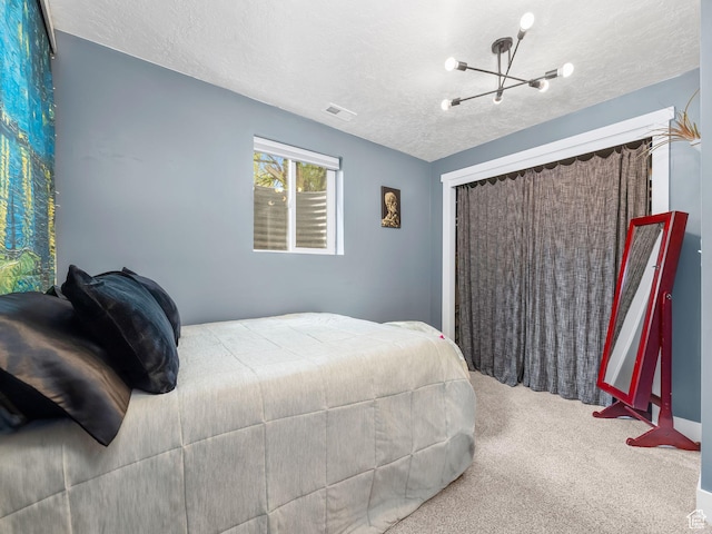 bedroom featuring visible vents, carpet, a textured ceiling, and a chandelier