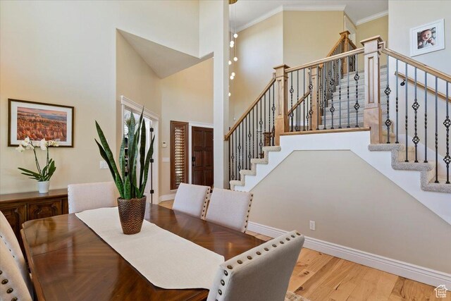 864 S Wellington Dr W, Kaysville, UT 84037 - dining space featuring a high ceiling, ornamental molding, wood finished floors, stairway, and baseboards