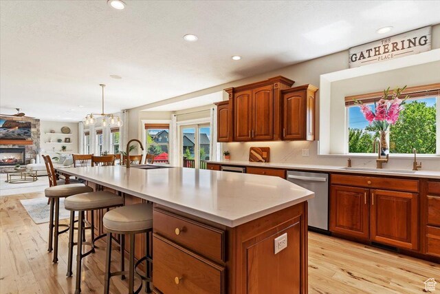 864 S Wellington Dr W, Kaysville, UT 84037 - kitchen with dishwasher, a sink, light wood-style flooring, open floor plan, and light countertops