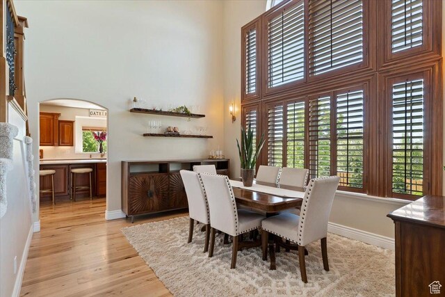 864 S Wellington Dr W, Kaysville, UT 84037 - dining space with a towering ceiling, plenty of natural light, light wood finished floors, arched walkways, and baseboards