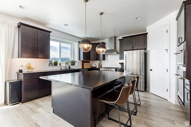 809 N 1490 E, Heber City, UT 84032 - kitchen featuring freestanding refrigerator, a sink, wall chimney exhaust hood, a breakfast bar, and dark brown cabinets