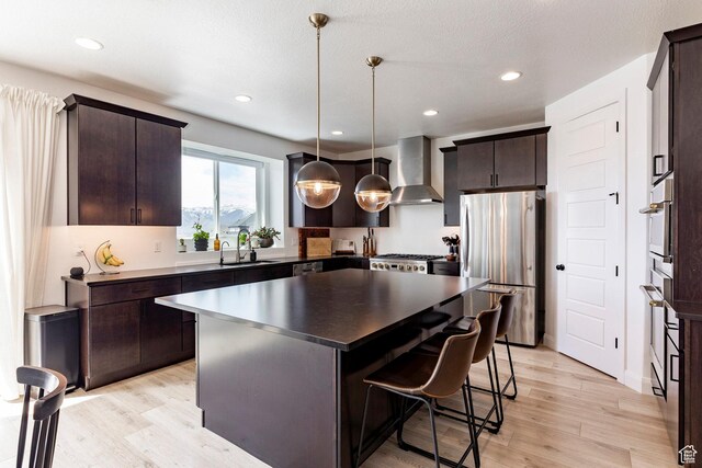809 N 1490 E, Heber City, UT 84032 - kitchen featuring appliances with stainless steel finishes, wall chimney range hood, dark brown cabinetry, and recessed lighting