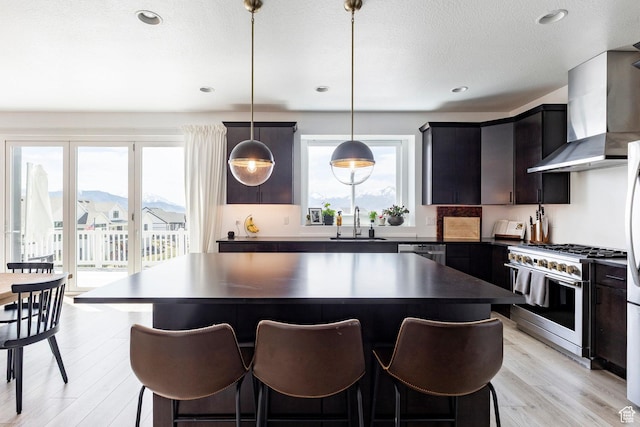 809 N 1490 E, Heber City, UT 84032 - kitchen with appliances with stainless steel finishes, wall chimney range hood, a sink, dark countertops, and a center island