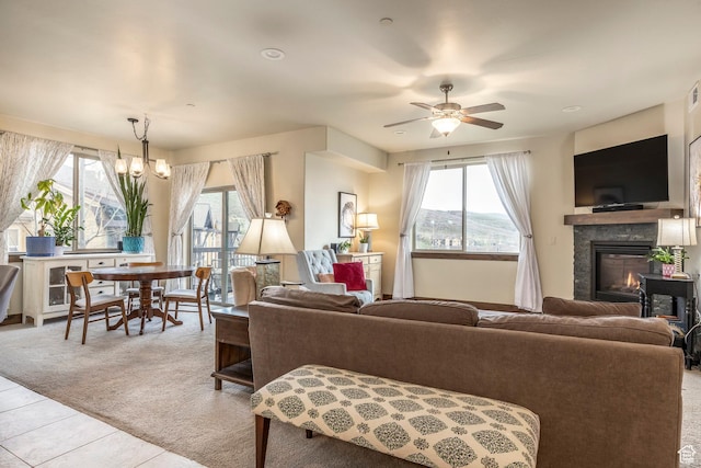 1261 W Black Rock Trl Unit 39F, Kamas, UT 84036 - carpeted living area featuring tile patterned floors, a glass covered fireplace, plenty of natural light, and ceiling fan with notable chandelier