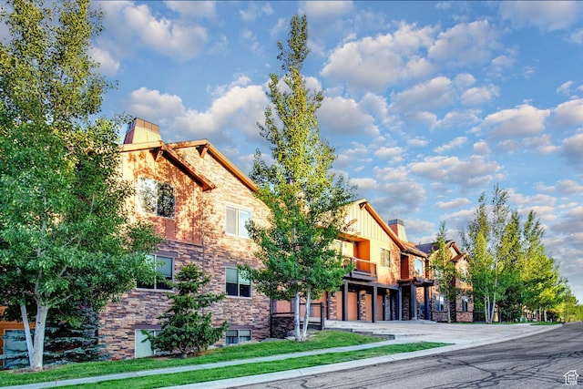 1261 W Black Rock Trl Unit 39F, Kamas, UT 84036 - view of front of home with a garage, a balcony, driveway, and stone siding