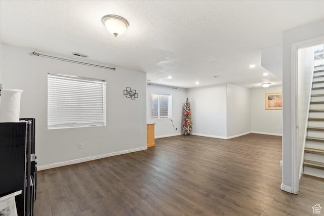 6268 S Faber Ln, Taylorsville, UT 84123 - unfurnished living room featuring baseboards, visible vents, dark wood finished floors, and stairway