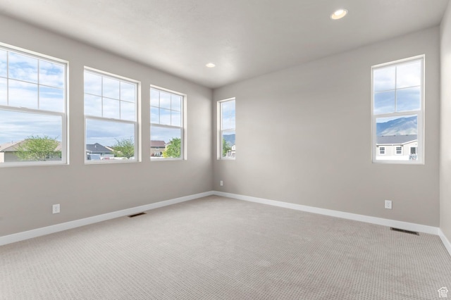 spare room featuring light carpet, baseboards, and recessed lighting