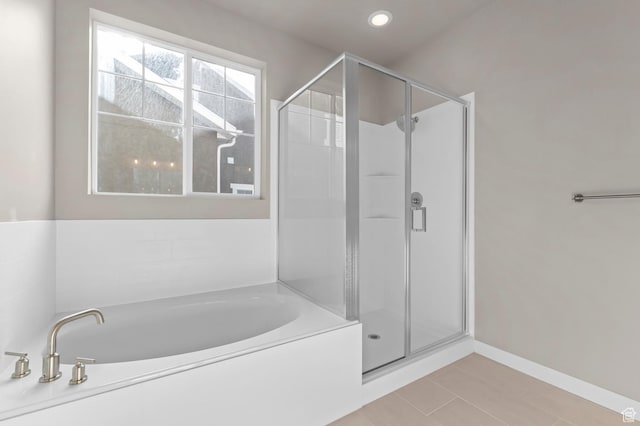 full bathroom featuring a stall shower, a garden tub, tile patterned flooring, and baseboards
