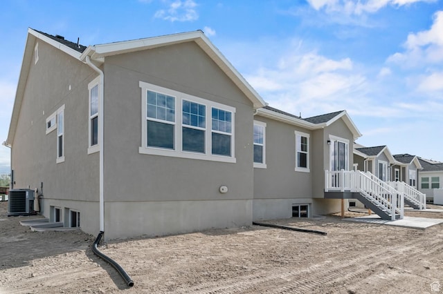view of side of property featuring stucco siding and central AC