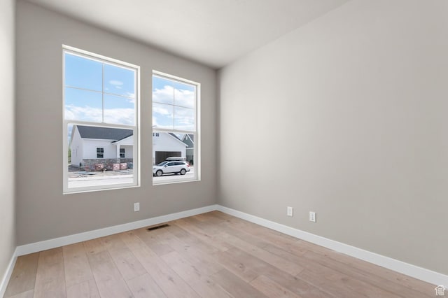 unfurnished room with baseboards and light wood finished floors