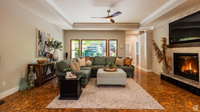 11606 S Radience Ln W, South Jordan, UT 84009 - living area featuring a ceiling fan, crown molding, a stone fireplace, a tray ceiling, and a textured ceiling