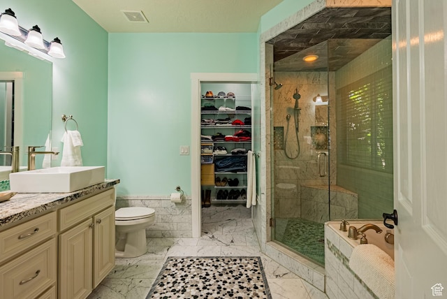 11606 S Radience Ln W, South Jordan, UT 84009 - bathroom featuring vanity, a stall shower, marble finish floors, a spacious closet, and wainscoting