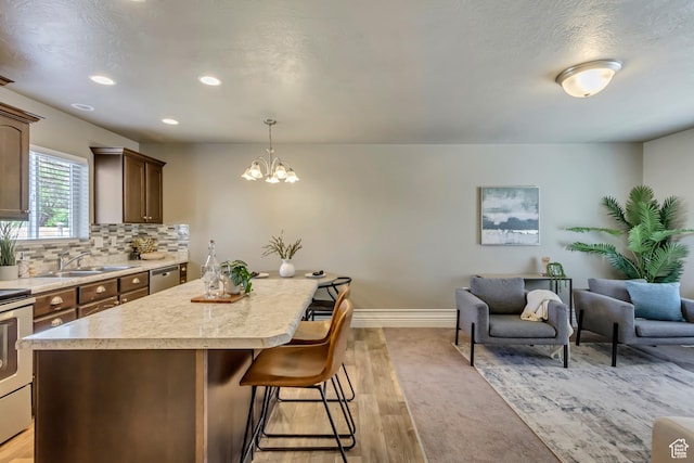145 E Majestic Elms Pl S, South Salt Lake, UT 84115 - kitchen featuring an inviting chandelier, a breakfast bar area, recessed lighting, light countertops, and a sink