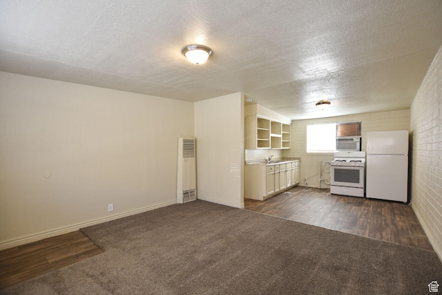 kitchen featuring open shelves, a sink, white appliances, a heating unit, and dark colored carpet