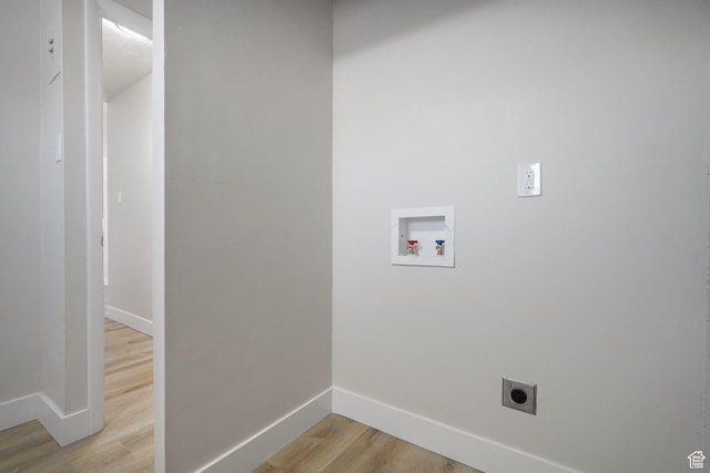 clothes washing area with baseboards, hookup for a washing machine, light wood-style flooring, and hookup for an electric dryer
