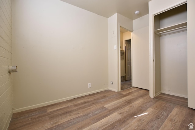 unfurnished bedroom with baseboards, a closet, and wood finished floors