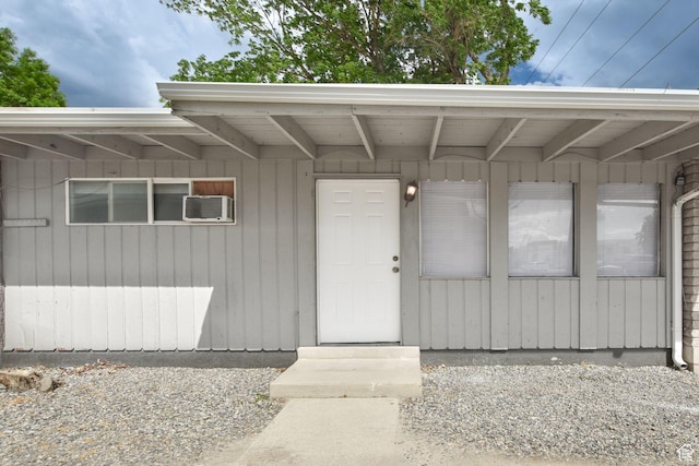 view of exterior entry with a wall unit AC