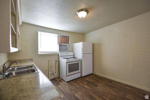 kitchen with white appliances, a textured ceiling, dark wood finished floors, and a sink