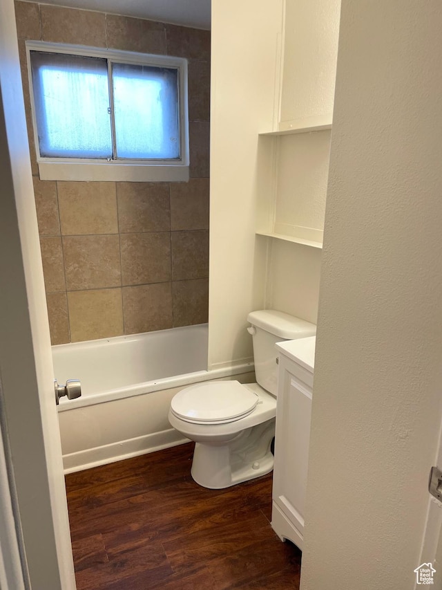 full bath with toilet, shower / tub combination, wood finished floors, and vanity