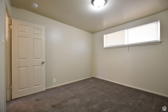 unfurnished room featuring baseboards and carpet