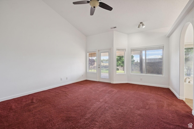 carpeted empty room with a healthy amount of sunlight, baseboards, a ceiling fan, and visible vents