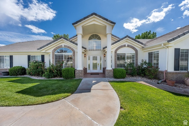 doorway to property with brick siding, stucco siding, and a yard
