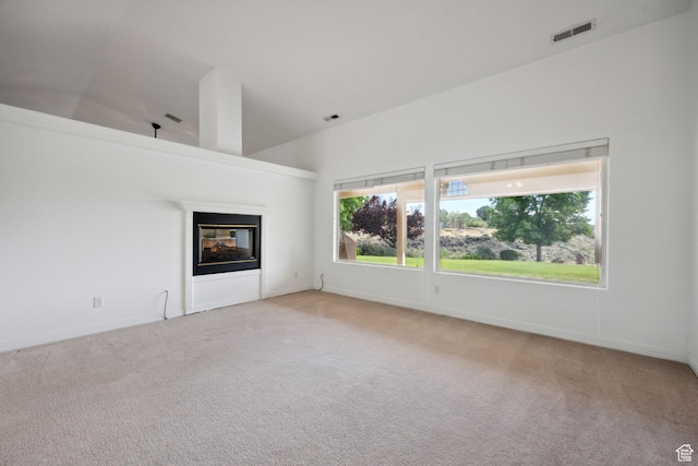 unfurnished living room with carpet flooring, baseboards, visible vents, and a multi sided fireplace