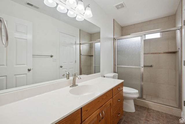 bathroom featuring visible vents, a stall shower, toilet, and vanity