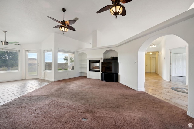 unfurnished living room featuring carpet floors, baseboards, ceiling fan, and tile patterned floors