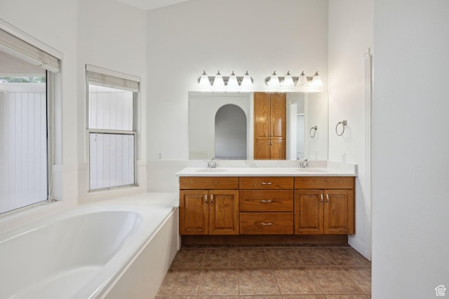 full bath with double vanity, a sink, a bath, and tile patterned floors