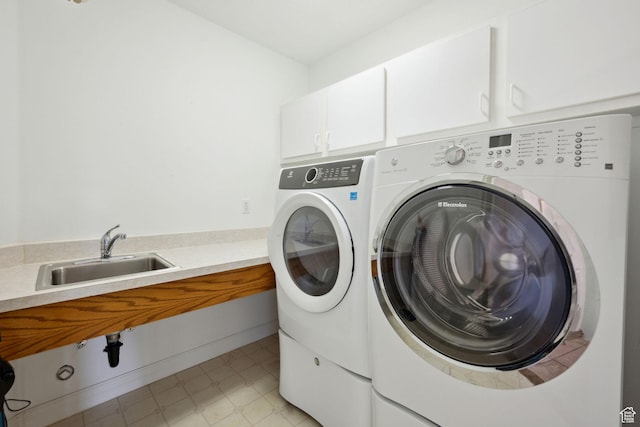laundry area with light floors, a sink, cabinet space, and independent washer and dryer