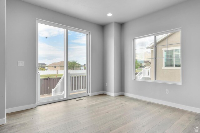 unfurnished room featuring baseboards, wood finished floors, and recessed lighting