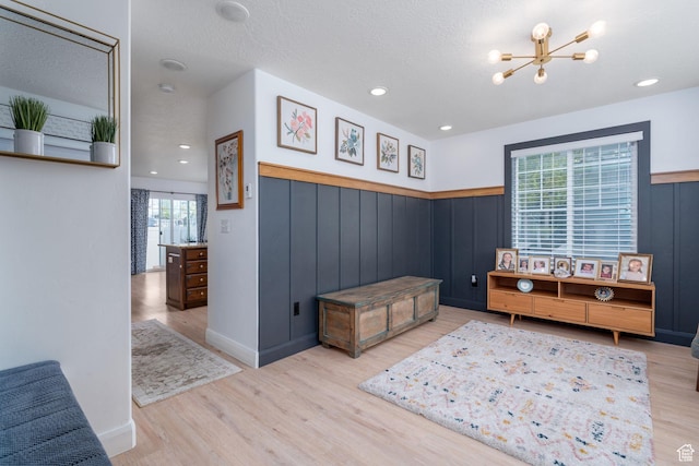 interior space with wainscoting, wood finished floors, and a chandelier