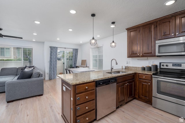 2046 W 1100 N, Provo, UT 84604 - kitchen featuring appliances with stainless steel finishes, light wood-type flooring, a sink, a peninsula, and open floor plan