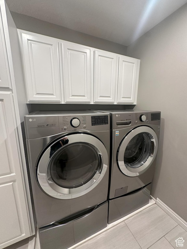 498 N 80 W, Lindon, UT 84042 - clothes washing area featuring washing machine and clothes dryer, baseboards, tile patterned floors, and cabinet space
