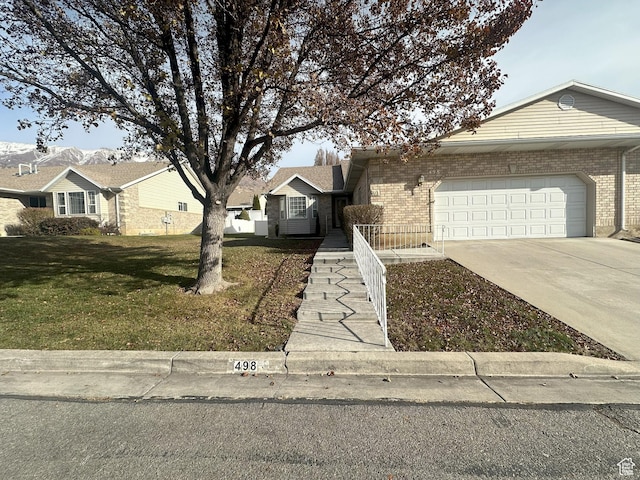 ranch-style house with brick siding, a garage, driveway, and a front yard