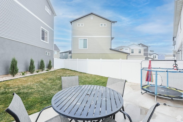 134 E Stroll Ave Unit 816, Saratoga Springs, UT 84045 - view of patio featuring outdoor dining area, a fenced backyard, and a trampoline