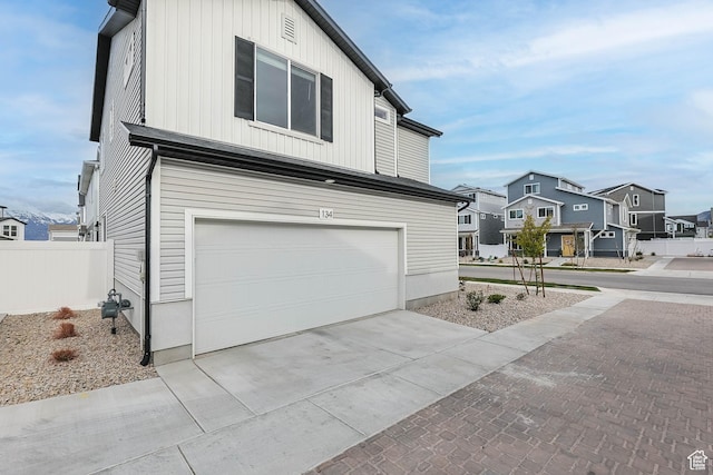 134 E Stroll Ave Unit 816, Saratoga Springs, UT 84045 - view of side of home with a residential view, fence, an attached garage, and concrete driveway