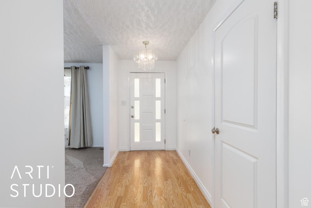 2732 S 4550 W, Taylor, UT 84401 - foyer entrance featuring an inviting chandelier, baseboards, light wood-style floors, and a textured ceiling