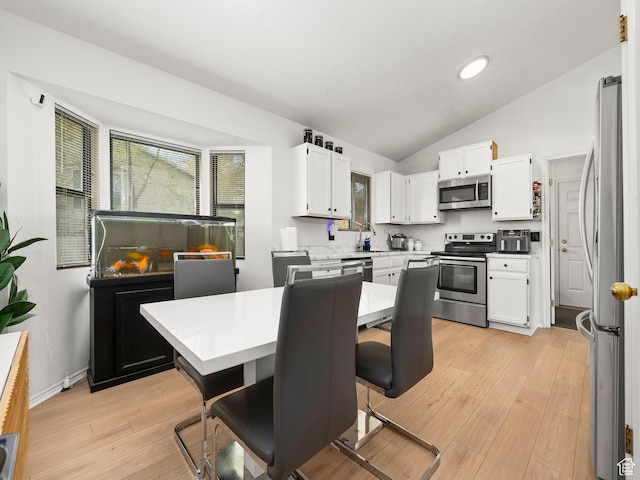 2265 W Marvinwood Dr S, Taylorsville, UT 84129 - kitchen with light countertops, appliances with stainless steel finishes, white cabinets, and vaulted ceiling