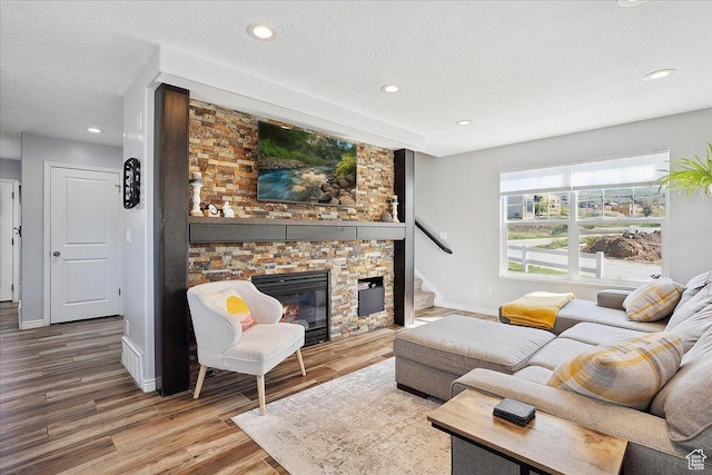 3511 N Willow Creek Ln E Unit 10, Eden, UT 84310 - living room with wood finished floors, a stone fireplace, baseboards, recessed lighting, and a textured ceiling