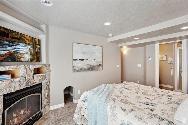 3511 N Willow Creek Ln E Unit 10, Eden, UT 84310 - bedroom featuring a stone fireplace, a textured ceiling, baseboards, carpet, and recessed lighting