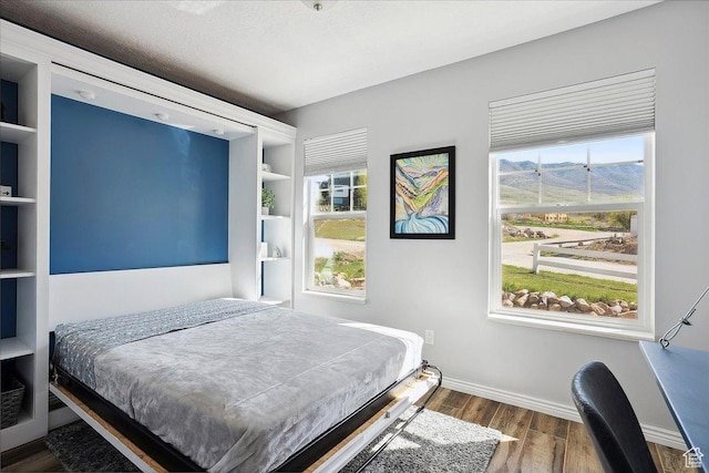 3511 N Willow Creek Ln E Unit 10, Eden, UT 84310 - bedroom with baseboards, a mountain view, and wood finished floors
