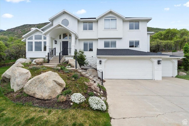 view of front of property with an attached garage, stucco siding, and driveway