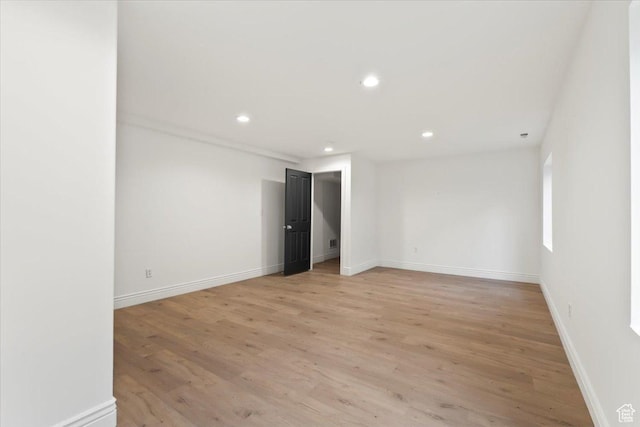 empty room featuring light wood finished floors, baseboards, and recessed lighting