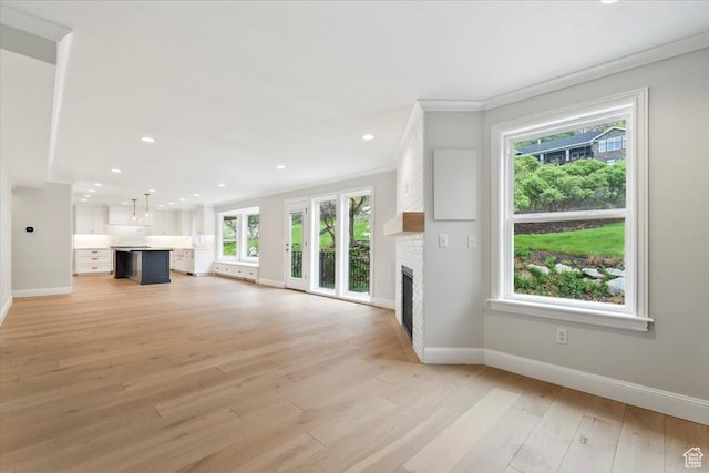 unfurnished living room with light wood-style flooring, a fireplace, baseboards, ornamental molding, and recessed lighting